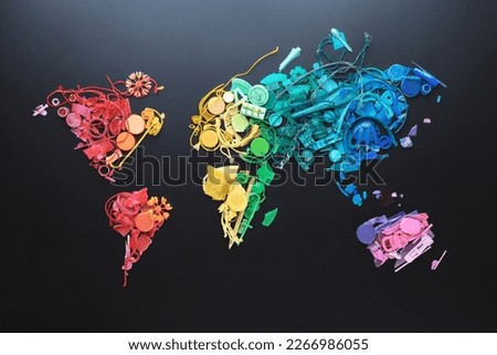 Map of world from rainbow bright colored pieces of non-decomposable garbage collected on beach during sea tide in Thailand. Concept of contaminated environment. Whole world is under threat of plastic