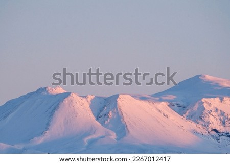 Snowed mountain top in Iceland in morning sun pink and blue  Royalty-Free Stock Photo #2267012417