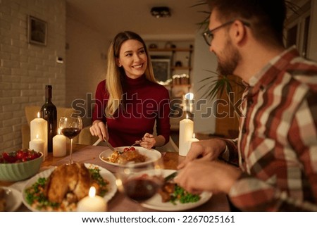 Beautiful couple having romantic dinner with candles and red wine at home Royalty-Free Stock Photo #2267025161