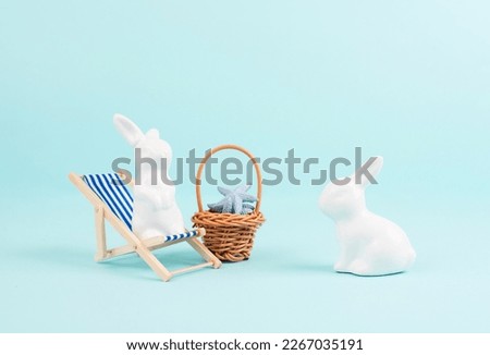 Bunny or rabbit sitting on lounge chair, basket with sea stars, easter holiday, vacation by the sea
