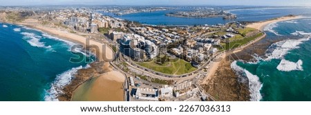 Panoramic aerial drone view of the harbour city of Newcastle, NSW, Australia as a cargo ship enters Newcastle Harbour on a sunny day  Royalty-Free Stock Photo #2267036313