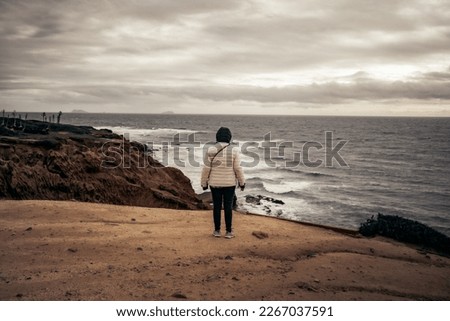Woman Standing on cliff overlooking the ocean - Pacific ocean - cloudy day - sunset cliffs