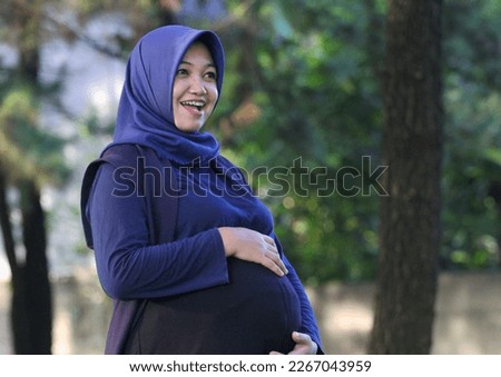Beautiful Asian pregnant woman wearing blue hijab