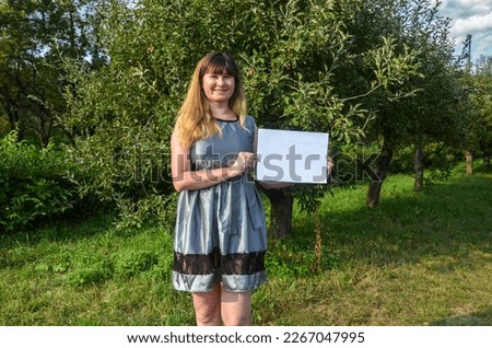 Woman holding blank of a white sheet of paper. Placard board for your text 