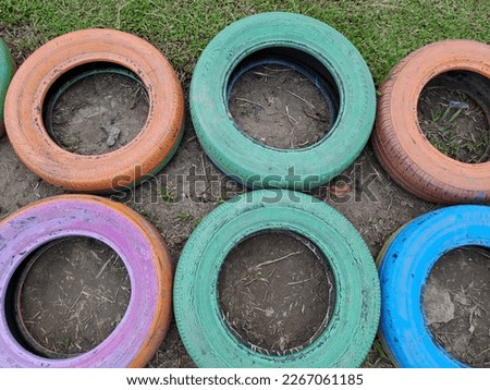 Painted tires are placed in lines which are used to create obstacles in the children's play area