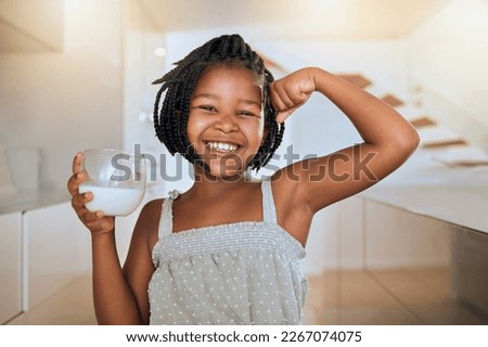 Milk, portrait and African girl with muscle from healthy drink for energy, growth and nutrition in the kitchen. Happy, smile and child flexing muscles from calcium in a glass and care for health Royalty-Free Stock Photo #2267074075