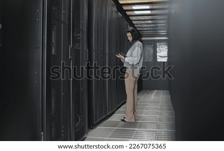 Tablet, server room and data center with a programmer asian woman at work on a computer mainframe. Software, database and information technology with a female coder working alone on a cyber network Royalty-Free Stock Photo #2267075365