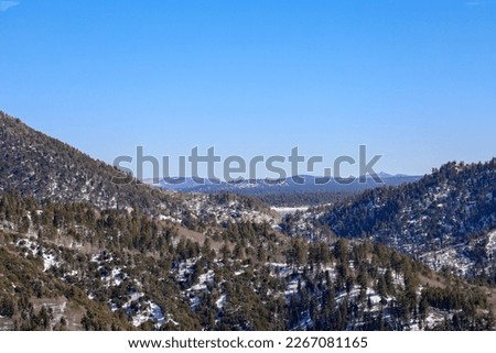 View of the snow capped San Bernardino Mountains and Big Bear Lake on the horizon from the side of highway 18. Southern California, USA.