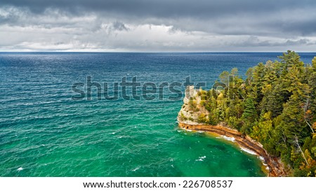 Long exposure shows the whitewater of the Hurricane River flowing across a beach and into Lake Superior surf on a cloudy day at Pictured Rocks National Lakeshore in Michigan's Upper Peninsula.