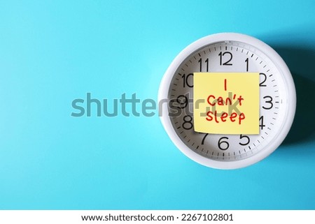 On copy space blue background, alarm clock with handwritten text note I CAN'T SLEEP, concept of insomnia or sleep deprived, when one have trouble sleeping or struggle to fall asleep at night Royalty-Free Stock Photo #2267102801