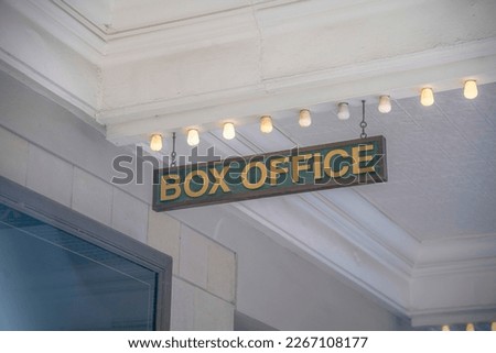 Hanging wooden Box Office sign in an establisment at San Antonio, Texas. Low angle view of a signage hanging on a white ceiling with row of light bulbs.