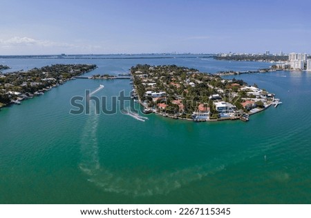 Miami Florida landscape with aerial view of the man made Intracoastal Waterway. Boat and houses built in the middle of the water can be seen under the blue sky.
