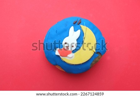 picture of a delicious round donuts rabbit with  
sugar glaze isolated on red background.homemade bakery concept and snacks and drinks .