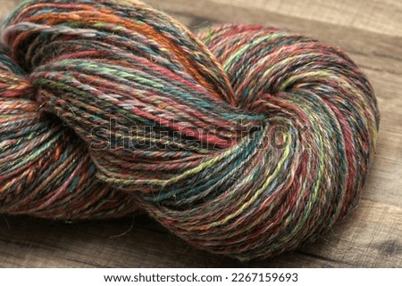 Closeup detail of colourful organic natural handspun and handdyed merino sheep wool yarn , spun on a traditional spinning wheel