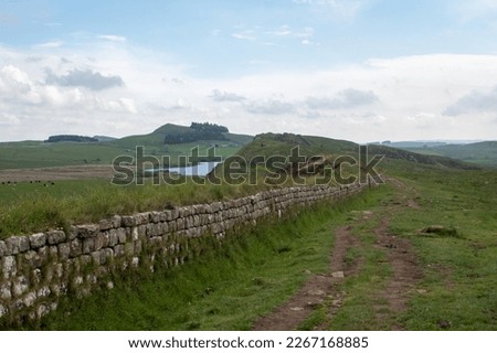 Views of Crag Lough in Northumberland National Park, against foreground of Whin Sill rocky crags and Hadrian's Wall  Royalty-Free Stock Photo #2267168885