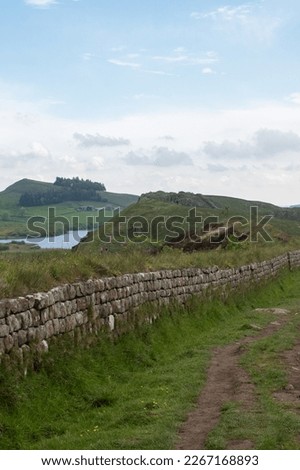 Views of Crag Lough in Northumberland National Park, against foreground of Whin Sill rocky crags and Hadrian's Wall  Royalty-Free Stock Photo #2267168893
