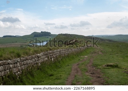 Views of Crag Lough in Northumberland National Park, against foreground of Whin Sill rocky crags and Hadrian's Wall  Royalty-Free Stock Photo #2267168895