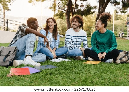 University student friends sitting on the grass, talking in the college campus - African American youth Royalty-Free Stock Photo #2267170825