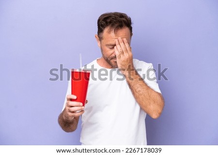 Middle age caucasian man holding soda isolated on purple background with tired and sick expression Royalty-Free Stock Photo #2267178039