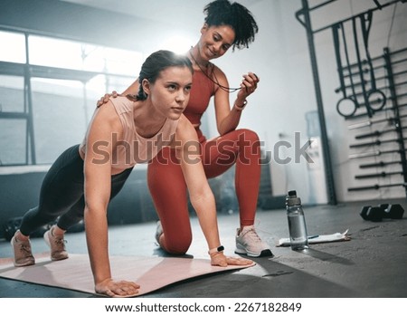Personal trainer, fitness and stopwatch with a black woman coaching a client in a gym during her workout. Health, exercise or training and a female athlete doing a plank with her coach recording time Royalty-Free Stock Photo #2267182849