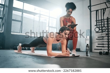 Personal trainer, fitness and clipboard with a black woman coaching a client in a gym during her workout. Health, exercise or training and a female athlete doing a plank with her coach writing notes Royalty-Free Stock Photo #2267182881