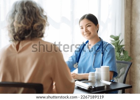 Female doctor consulting senior old patient filling form at consultation, talking to senior old patient filling signing medical paper at appointment visit in clinic.