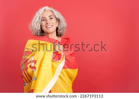 Smiley woman wrapping with a spanish national flag