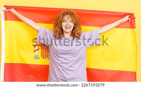 Happy beauty woman raising a spanish national flag