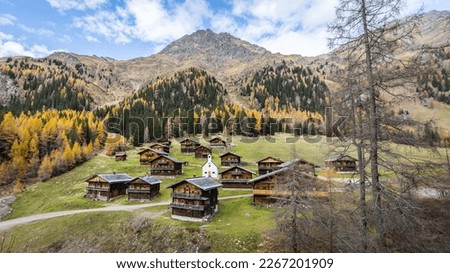 Idyllic group of historic wooden farm houses on a alpine pasture in Austria during autumn Royalty-Free Stock Photo #2267201909