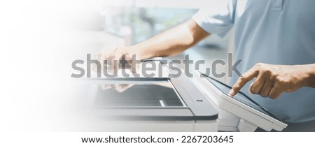 Photocopier printer, Close up hand office man press copy button on panel to using the copier or photocopy machine for scanning document or printing paper or Xerox a sheet. Royalty-Free Stock Photo #2267203645