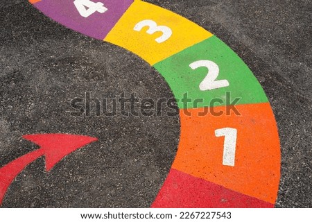 Snakes Board Game with Number on playground floor,Bright colored paint with number One,Two,Three,Four with Red arrow on pavement ,Ourdoor activity for Kids,Learn and Play for Kindergarten school 