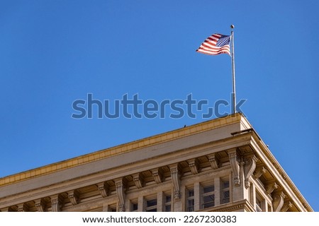 A picture of the American flag atop a building in Downtown Los Angeles.