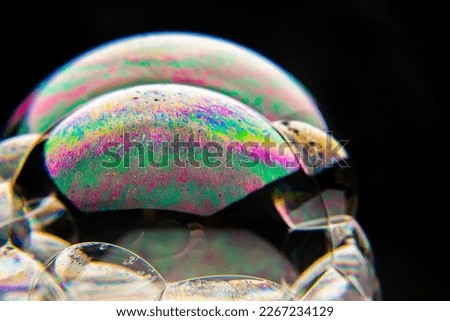 a soap bubble that shimmers in different colors.Thanks to macro photography, you can see the details of the internal structure of the bubble and its iridescence with shades from white to bright colors