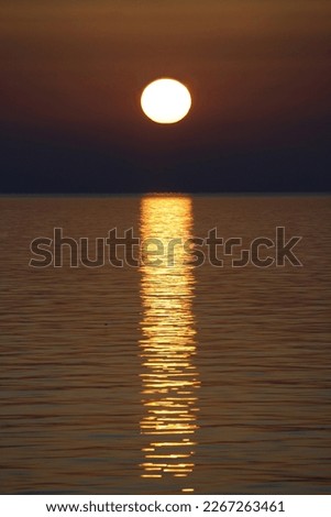 Summer sunset on the Mediterranean sea, warm sunlight reflection on calm water. Photo taken from the island of Lampedusa, Sicily, Italy  