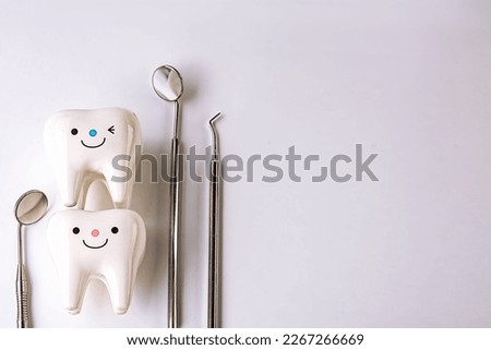 on a white background figurines of teeth and dentist tools.Whitening tooth and dental health on treatment background with cleaning teeth