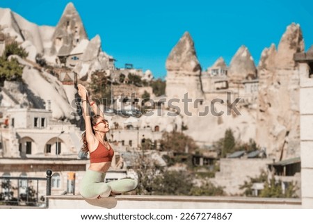 Happy girl doing some yoga exercises and meditation in Cappadocia Goreme authentic village - famous for its balloons and unique energy