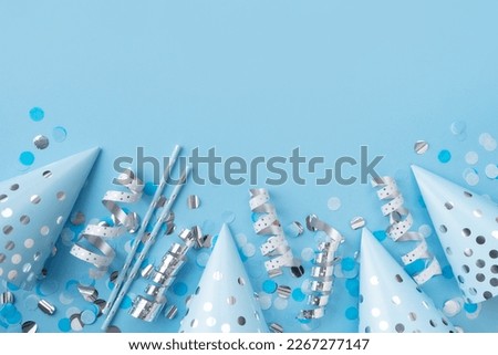 Boy, baby birthday, celebration, fathers day concept with celebration cone and confetti on blue background, top view, copy space