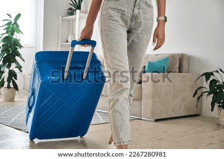 Unrecognizable woman leaving home with a suitcase going on a trip or vacation Royalty-Free Stock Photo #2267280981