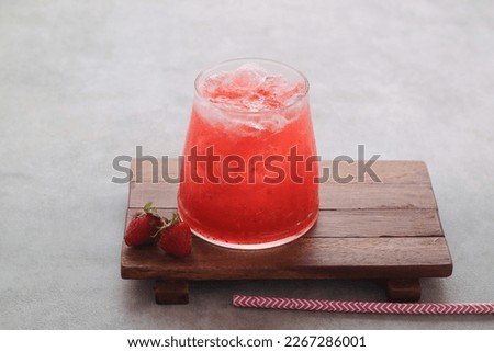a glass of fresh strawberry juice isolated on gray background