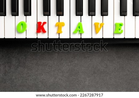 The word octave is composed of multicolored letters on the piano keys. Copy space.	 Royalty-Free Stock Photo #2267287917