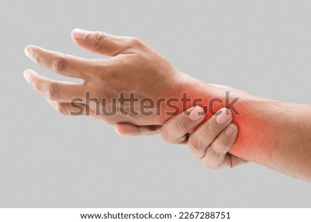 The man has numbness in the forearm on a gray background. Health care and body care concept.