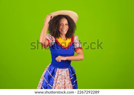 Portrait of a beautiful young black woman dressed for the Festa Junina dancing a forró. Young afro woman with festa junina costume