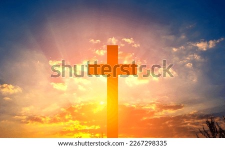 Cross in the rays of the sun against a blue cloudy sky.  Banner for text about religion.