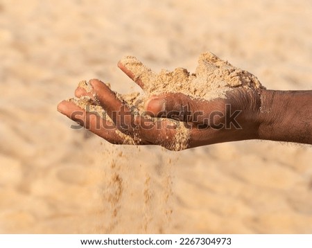 Climate change. Man holding sand in his hand. Symbolic representation of desertification and drought. Photo