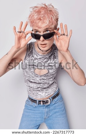 Gender expression. Fashionable tansgender man with pink hairstyle wears trendy sunglasses grey t shirt and jeans expresses his gender identities in different ways through clothes and behaviour Royalty-Free Stock Photo #2267317773