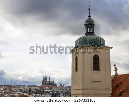 view of the tower of St. Jacob's Church with Prague Castle in the background