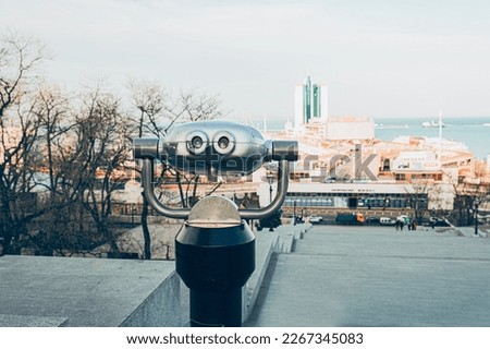 Touristic telescope look at the city with view of Odessa, Ukraine, close up old metal binoculars on background viewpoint overlooking the city port, coin operated binoculars