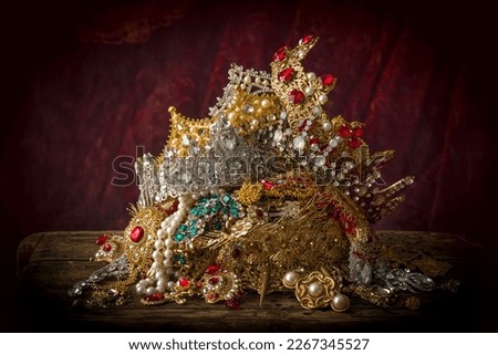 Romantic image of a treasure chest filled with jewellery, precious gems and golden king's crowns Royalty-Free Stock Photo #2267345527