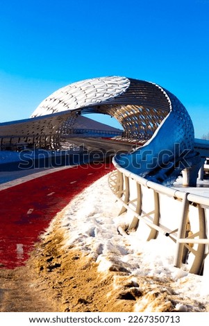 Modern bridge and modern architece in Astana in the capital of Kazakhstan on a sunny day with transport infrastruce and a red bike path