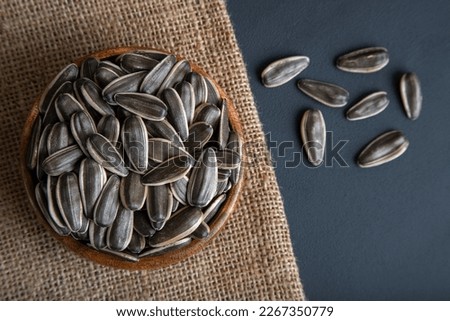 Black sunflower seeds in a bowl, on black background,top view